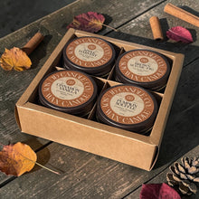 Load image into Gallery viewer, JD Candle Co. 4-pack autumn soy wax candle gift set featuring Apple Harvest, Brown Sugar Fig, Cinnamon Vanilla, and Pumpkin Souffle scents in 4 oz jelly jars and a brown lid, packaged in a brown cardboard box on a rustic wooden background with fall leaves.