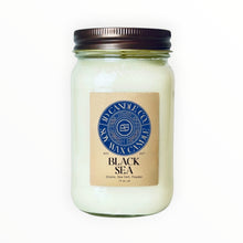 Load image into Gallery viewer, JD Candle Co. Black Sea scented candle in a 16 oz mason jar with a dark bronze lid. Features a label with scent notes of ozone, sea salt, and powder.