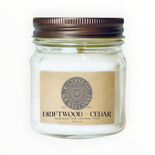 Load image into Gallery viewer, JD Candle Co. Driftwood + Cedar scented candle in an 8 oz glass jar with a rustic brown lid. Features a kraft paper label with gray, black and kraft branding.