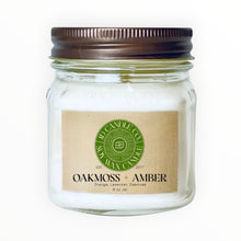 Load image into Gallery viewer, JD Candle Co. Oakmoss + Amber scented candle in an 8 oz glass mason jar with a bronze lid. White wax candle with a kraft paper label.