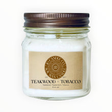 Load image into Gallery viewer, JD Candle Co. Teakwood + Tobacco 8 oz soy wax candle in a clear mason jar with a rustic brown lid. Features notes of allspice, clove, peppercorn, and amber.